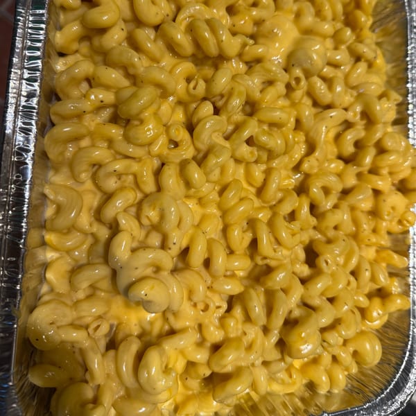 Creamy macaroni and cheese in a foil pan, a classic side dish from Duffy's BBQ and Grill.